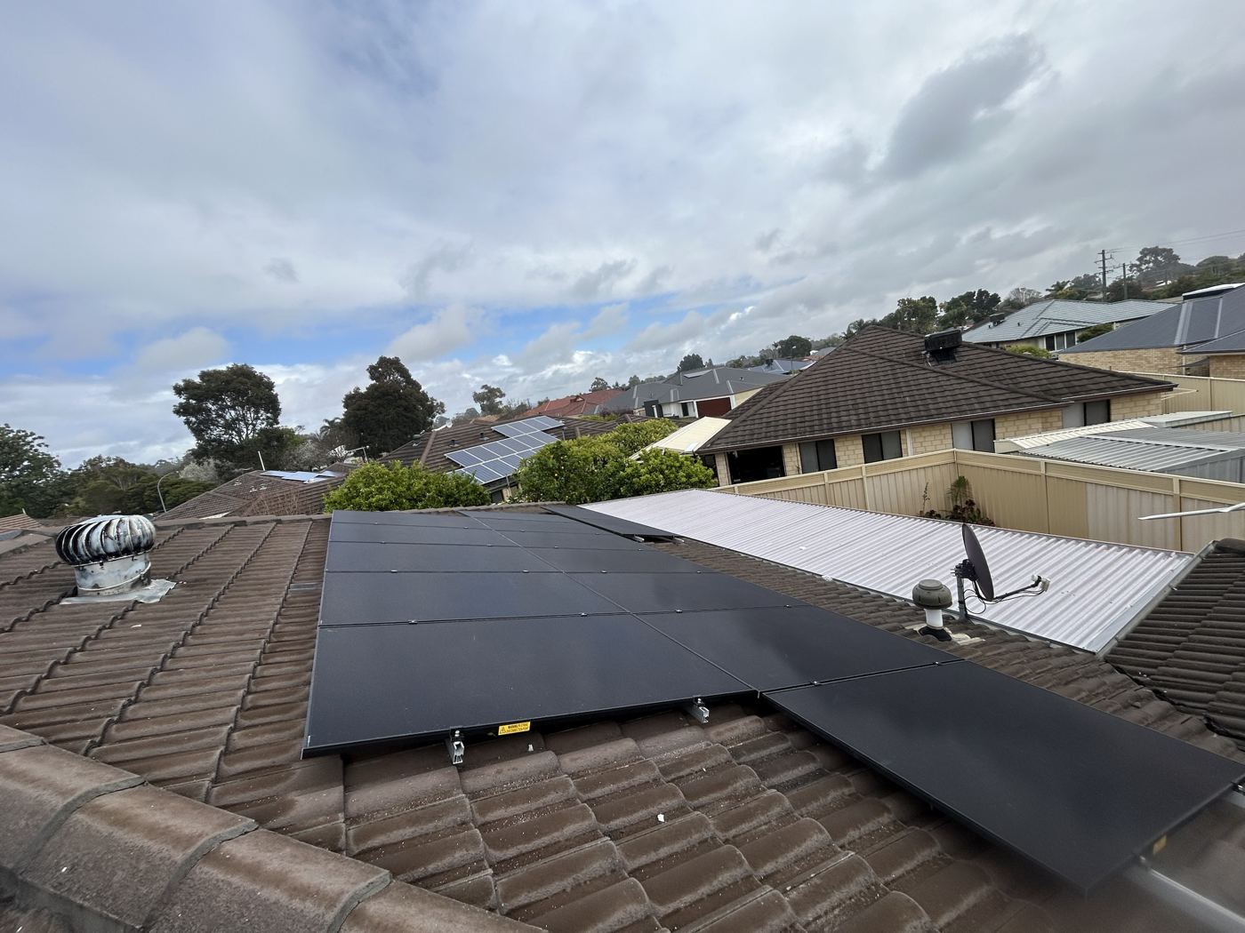 Black solar panels on a tiled roof in Perth