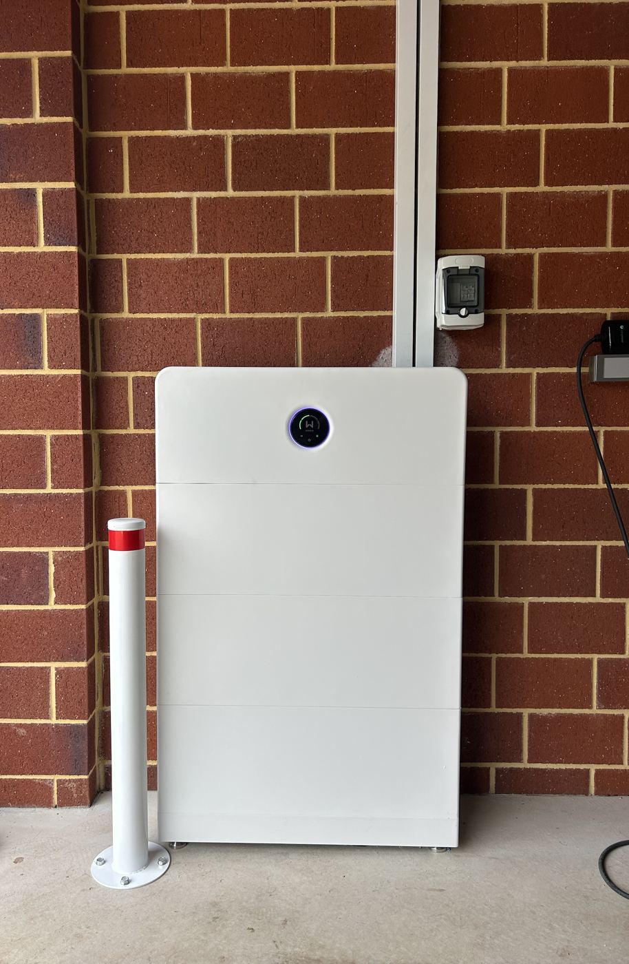 GoodWe battery installed on a red brick wall