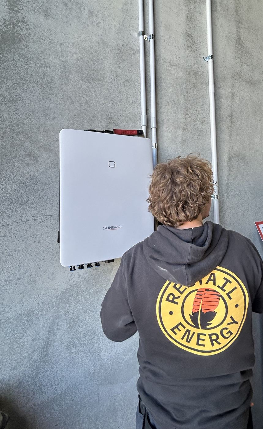Redtail Energy electrician installing a Sungrow inverter