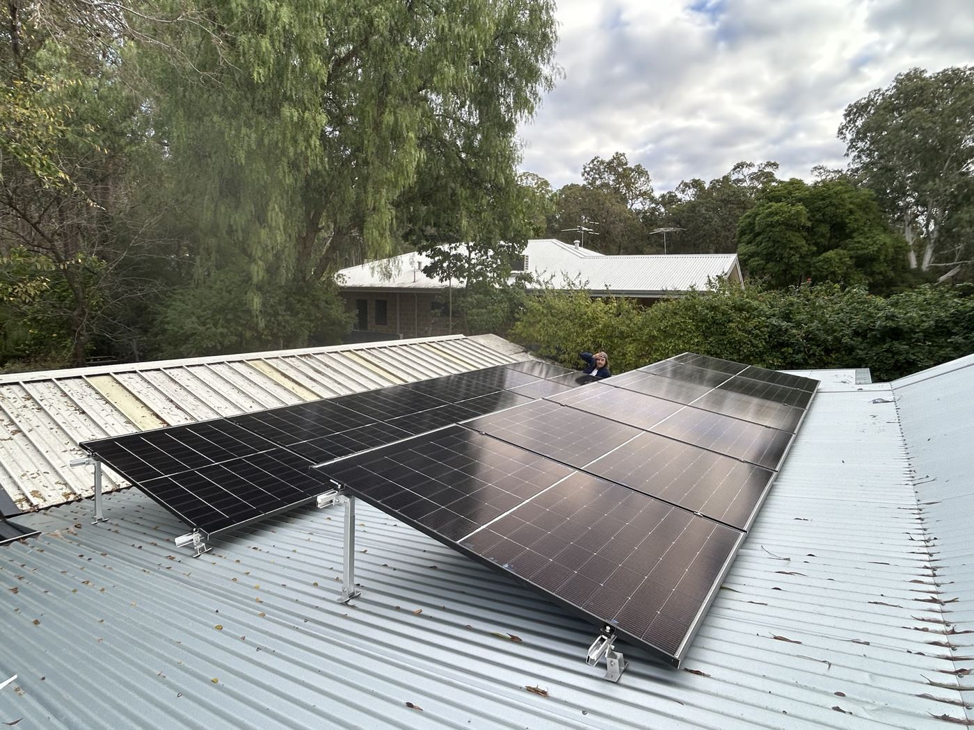 Tilted solar array on a metal roof among the trees