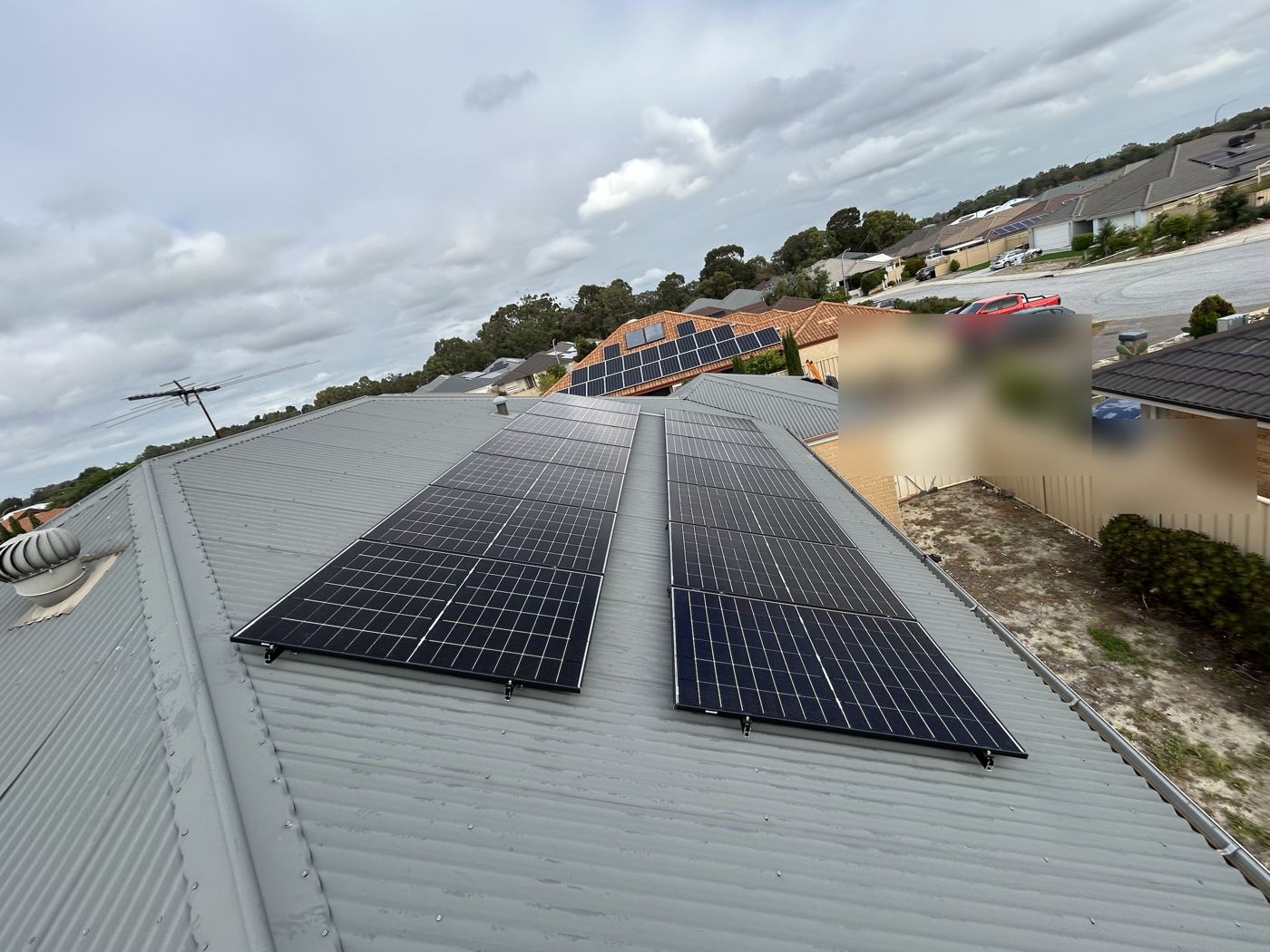 Solar panels on a grey Colorbond roof in a Perth estate